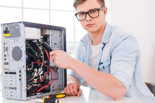 master-of-computers-portrait-of-handsome-young-man-repairing-computer-while-sitting-at-his-working-place-photo
